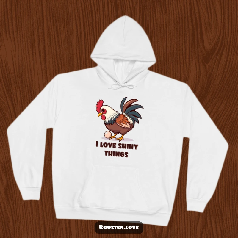 A comfortable, funny hoodie depicting a rooster playfully pecking at a shiny, oversized button, ideal for cozy days.